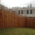 A large open space surrounded by a wooden fence. The fence has t type timber trellis fencing panels.