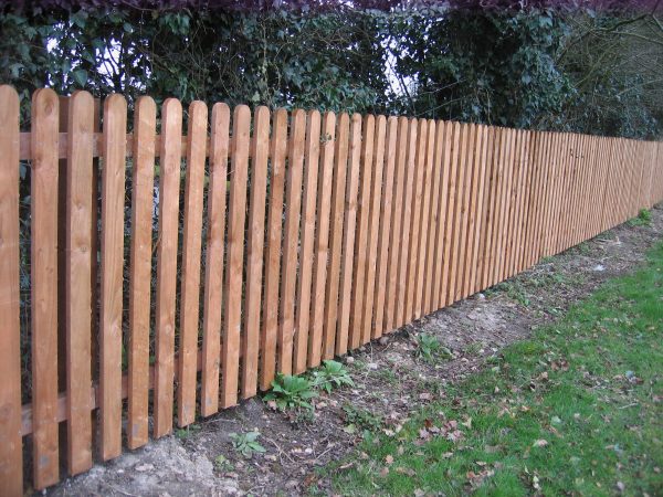 A long wooden fence constructed with timber pales.