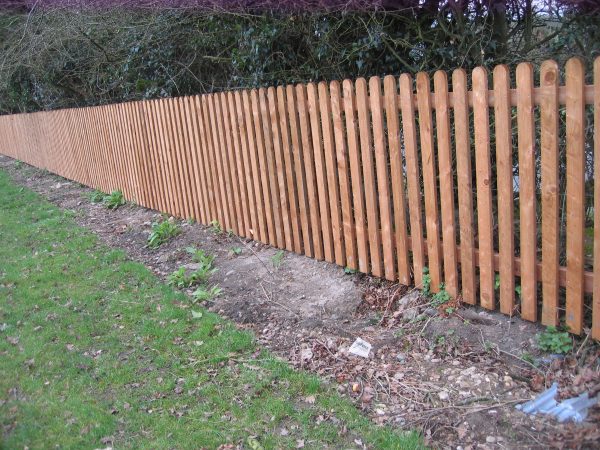 A wooden fence made up with timber pales.