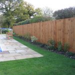 A large garden with a pool and large fence. The fence has feather edge boards and is pressure treated.
