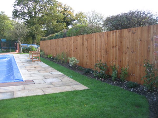 A large garden with a pool and large fence. The fence has feather edge boards and is pressure treated.