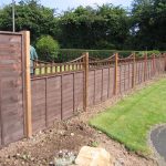 A large garden with a wooden fence. The fence has z type timber panels double framed, horizontally overlapped with bevelled capping.