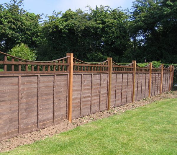 A long wooden fence with z type timber panels, double framed, horizontally overlapped with bevelled capping.