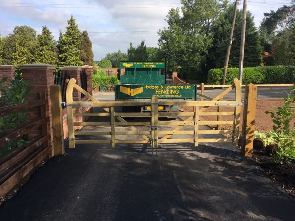 Hodges & Lawrence staff assembling a field gate on a private property. The gate is supported by timber gate posts.