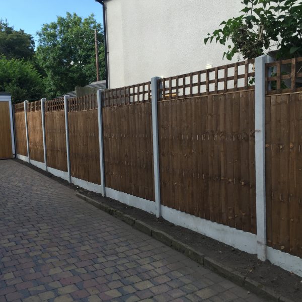 A long wooden fence. The fence has v type close board fence panels.