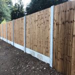 A wooden fence alongside a public walkway. The fence has close board fence panels.