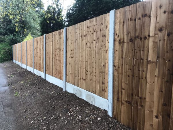 A wooden fence alongside a public walkway. The fence has close board fence panels.