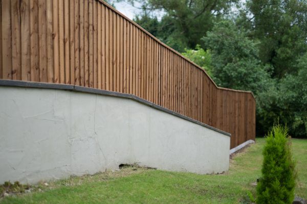 A large open area with a long fence. The fence has feather edge boards and is pressure treated.