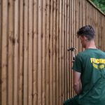 Hodges & Lawrence staff assembling a fence in a garden in Birmingham. The fence has feather edge boards.