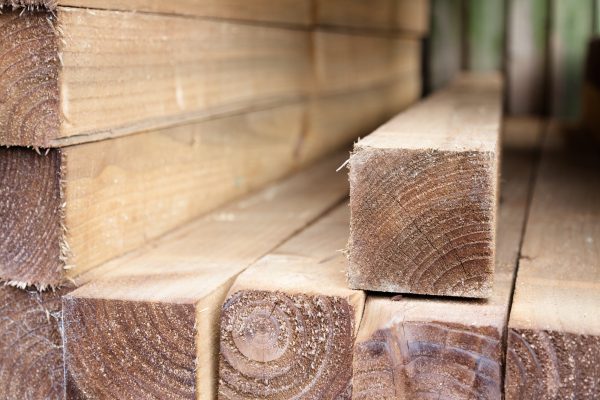 Pressure treated timber posts. The timber posts are light in colour and piled high in a fencing suppliers in Birmingham.