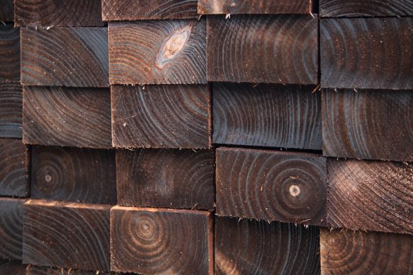 Pressure treated timber. The wood is dark in colour and is displayed in a fencing suppliers in Birmingham.