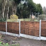Garden fence. The fence has z type timber panels double framed, horizontally overlapped with bevelled capping.