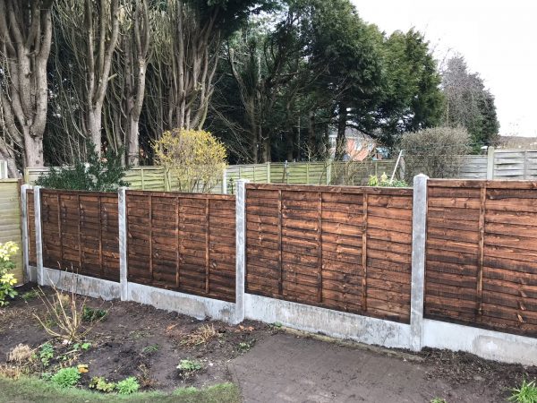 Garden fence. The fence has z type timber panels double framed, horizontally overlapped with bevelled capping.