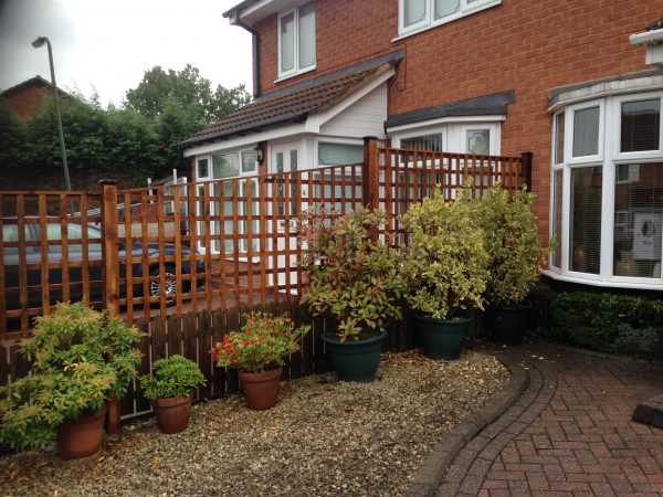 A fence dividing two houses in Birmingham. The fence has t type timber trellis fencing panels.