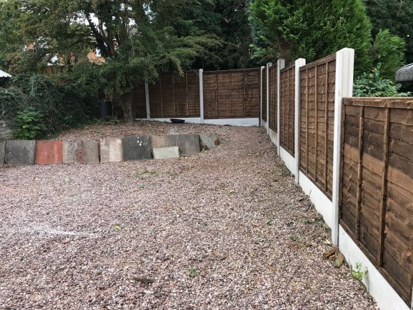 A wooden fence with z type timber panels, double framed, horizontally overlapped with bevelled capping.