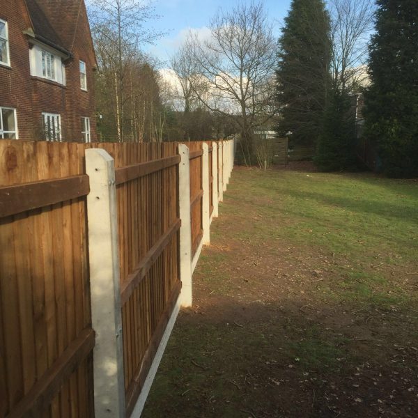 A wooden fence with concrete fence posts on display in a fencing suppliers in Birmingham.