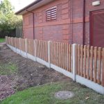Hodges & Lawrence staff assembling a fence in a commercial area in Birmingham. The fence is constructed using timber pales.